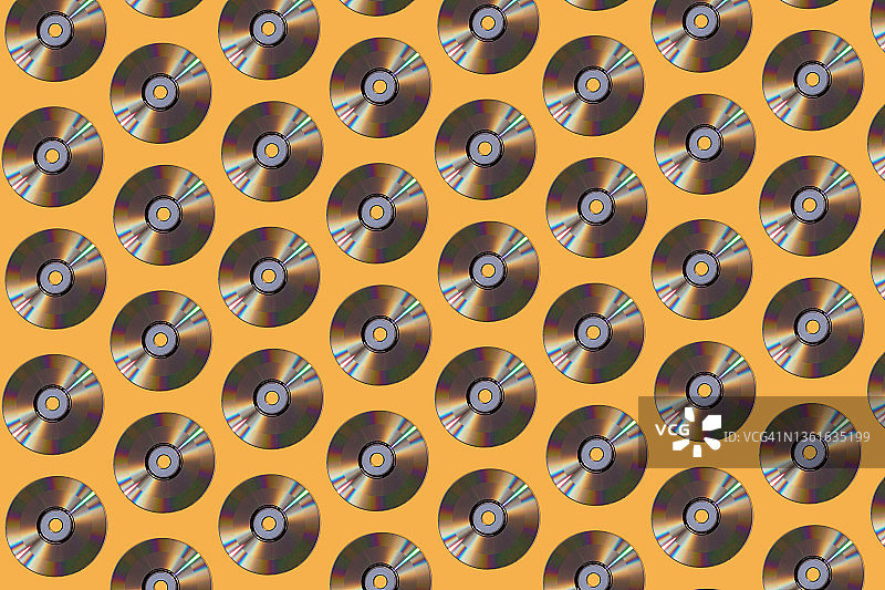 黄色背景上的银色CD光盘图案图片素材
