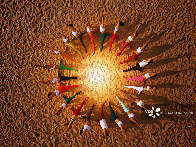 团队合作与商业概念：一群妇女在海滩上练习瑜伽图片素材