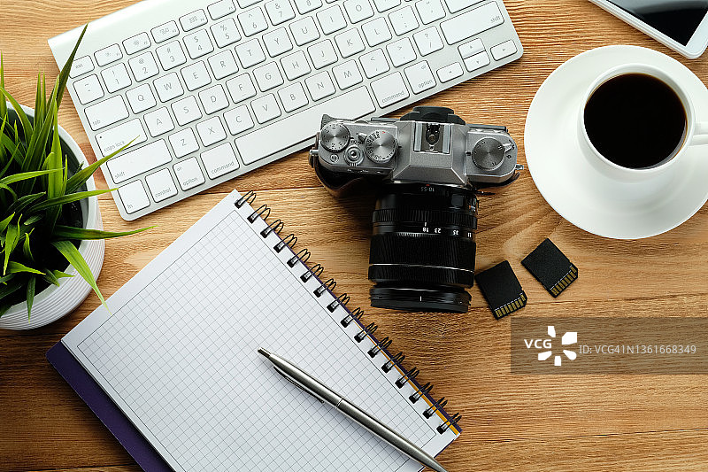 木桌上的手机、笔记本电脑键盘、笔、记事本、浓缩咖啡杯、闪存盘和相机图片素材