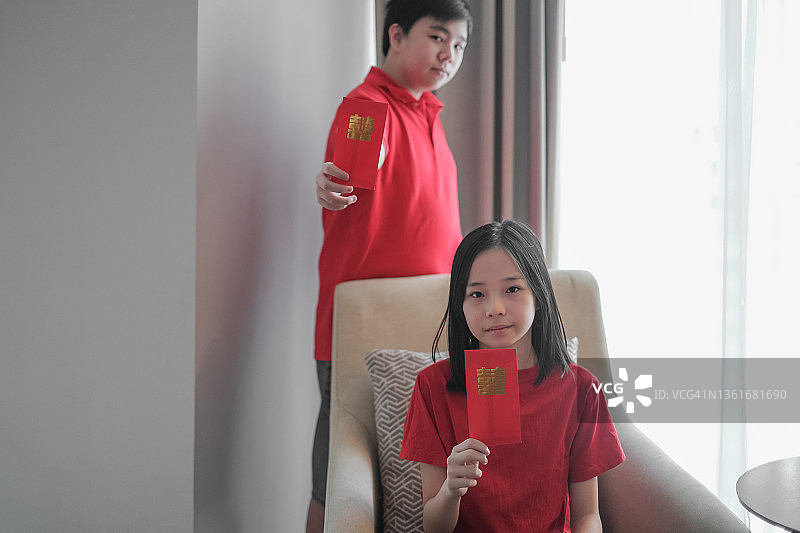 中国新年，展示红包的中国兄妹图片素材
