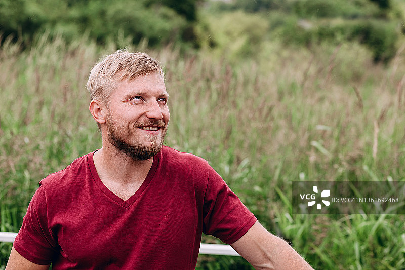 一位快乐的欧洲男子眺望远方，身穿勃艮第T恤的男人特写肖像图片素材