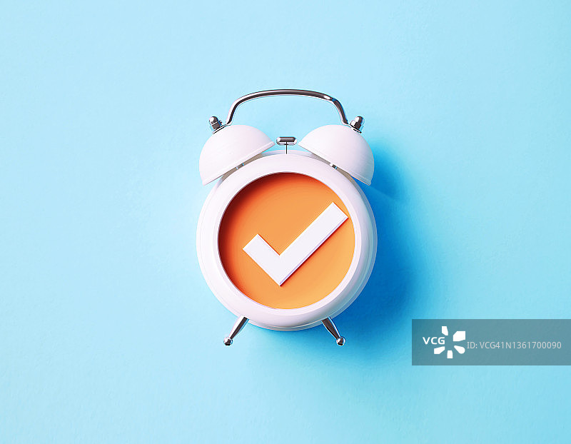 蓝色背景上的白色闹钟和选中标记图片素材