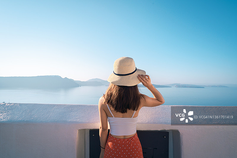 希腊圣托里尼岛，眺望爱琴海的亚洲女性肖像图片素材