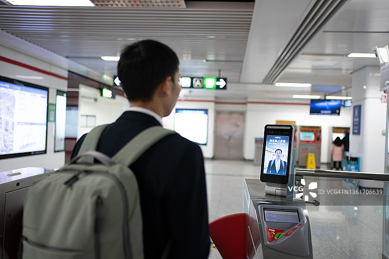 亚洲男人使用面部识别支付地铁车费图片素材