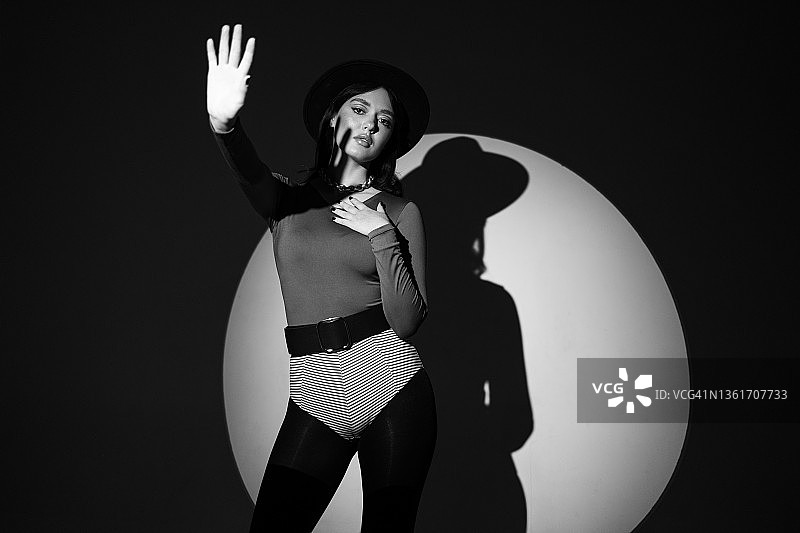 戴圆帽在影棚摆姿势的年轻漂亮女人 -  स्टॉक फोटो图片素材