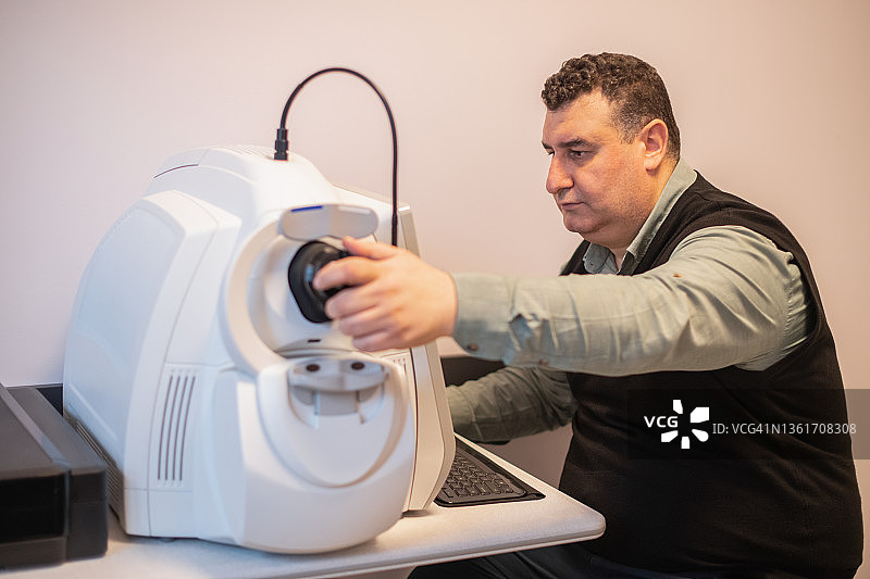技术员使用眼科光学相干断层扫描设备图片素材