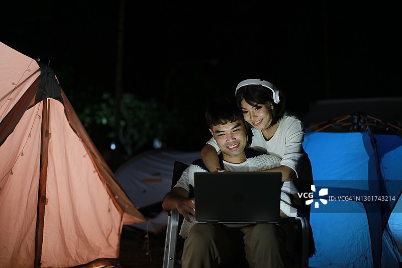 年轻漂亮的情侣在露营地远程工作图片素材