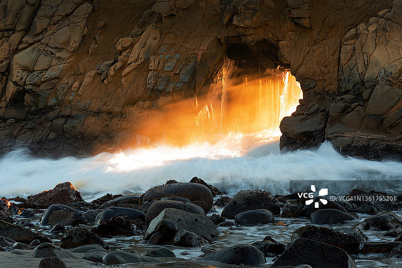 美国加利福尼亚州大苏尔，阳光穿过菲佛海滩的钥匙孔拱门图片素材