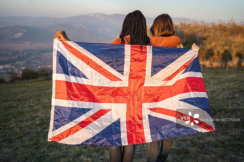 两位女士站在山上手持英国国旗图片素材