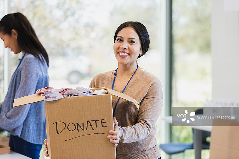 快乐的女人在慈善活动中做志愿者图片素材