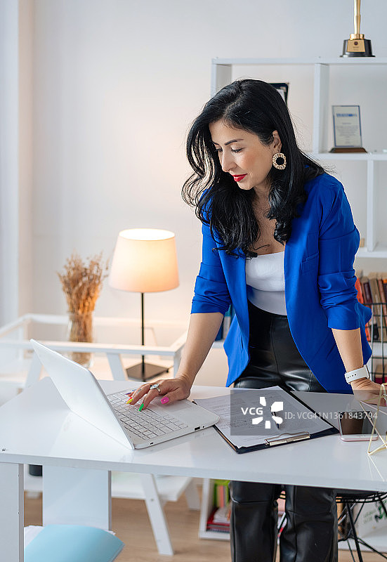 在家办公站立于桌前的女商人图片素材