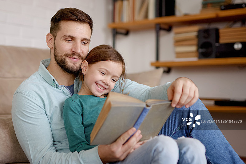 父亲在家给小女儿读书图片素材