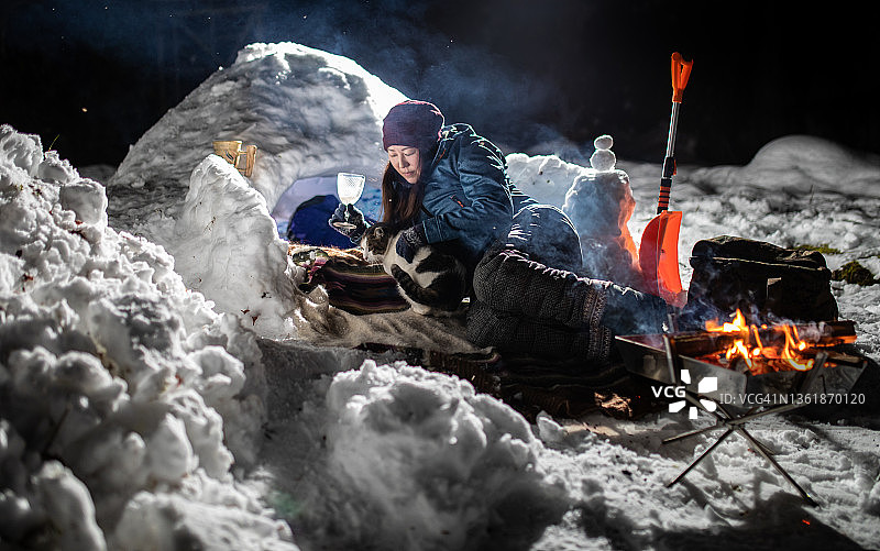 女士在雪地营地与猫咪一起放松图片素材