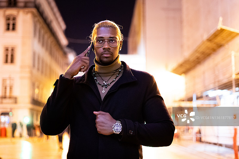 夜晚，站着打电话的时尚非洲男人图片素材
