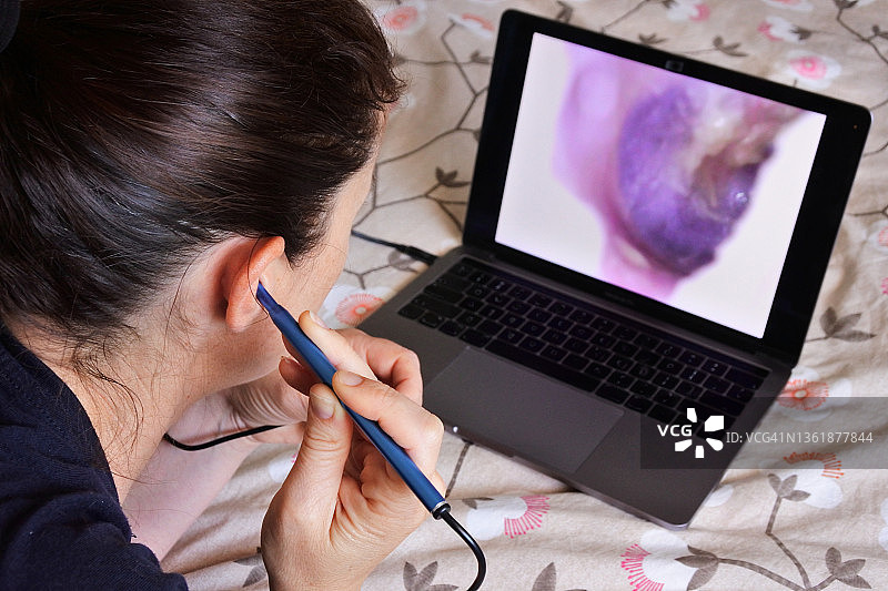 女人使用内窥镜可视采耳器清洁耳朵图片素材