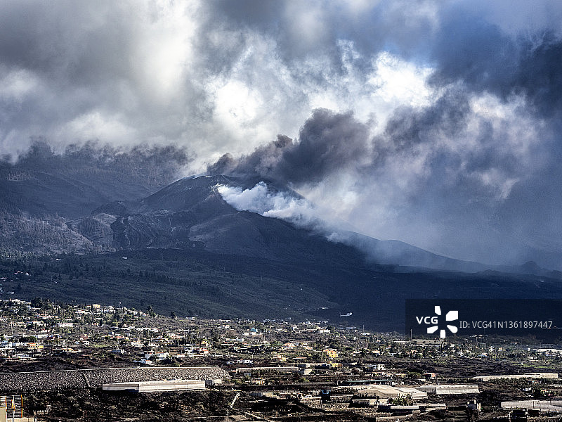 火山在城镇房屋旁喷发：拉帕尔马岛老峰火山图片素材