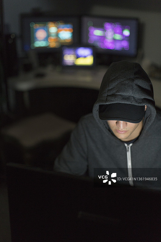 在黑暗房间里使用电脑的黑客图片素材