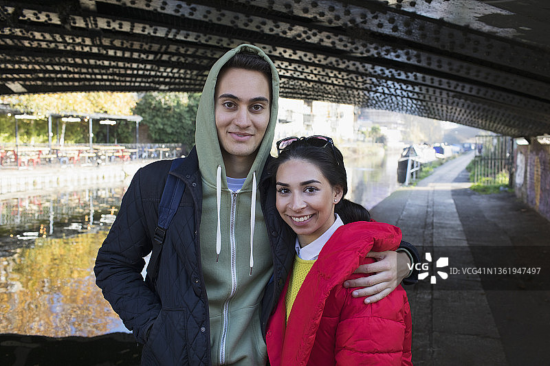 运河边拥抱的幸福年轻夫妇肖像图片素材