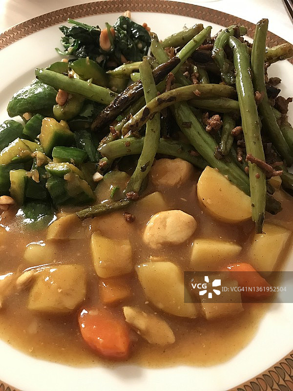 精美餐盘里的鸡肉咖喱和美味豆类图片素材