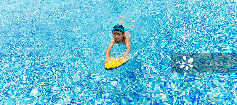 小男孩在游泳池里游泳图片素材