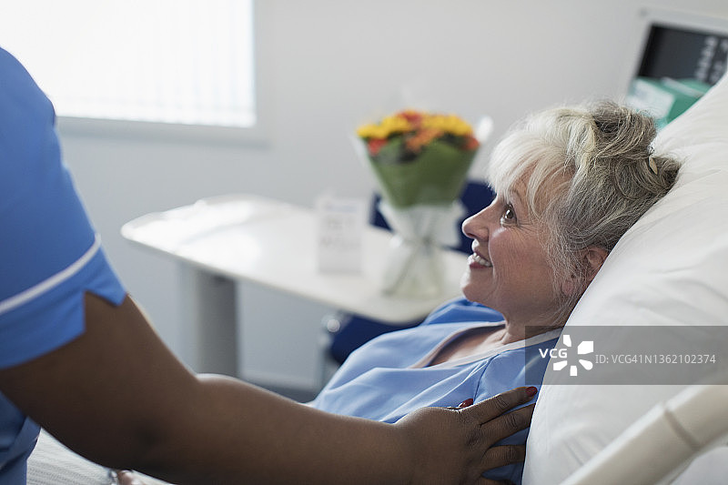 细心女护士在医院病床上安慰年长妇女图片素材