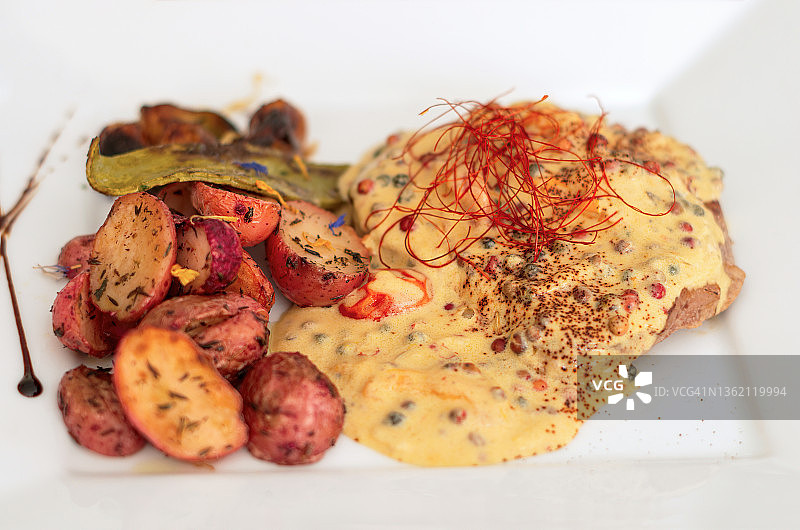 三种胡椒酱牛肉里脊配烤土豆、洋葱和仙人掌图片素材