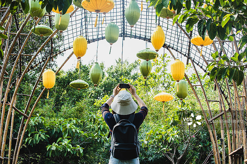 女游客用手机拍摄丝绸灯笼的背面图图片素材
