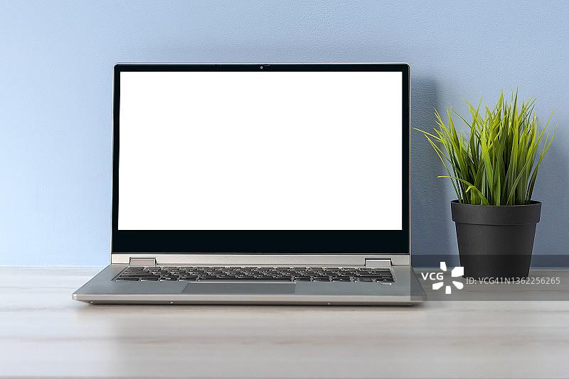 办公桌上带有白色屏幕的笔记本电脑图片素材