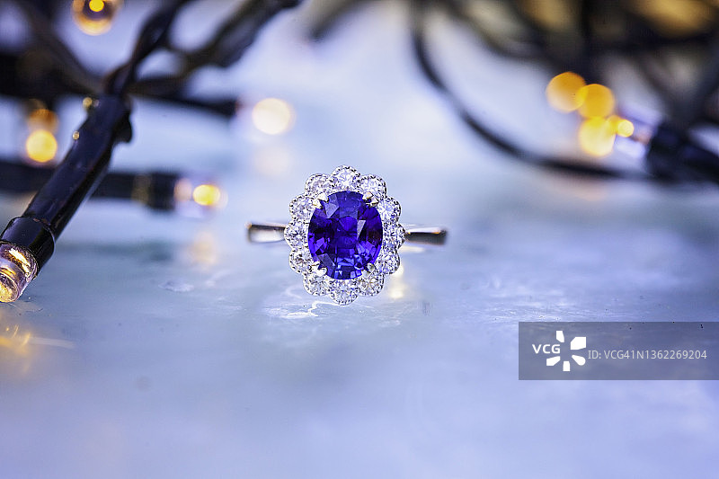 磨砂冰背景上的蓝宝石钻石戒指图片素材