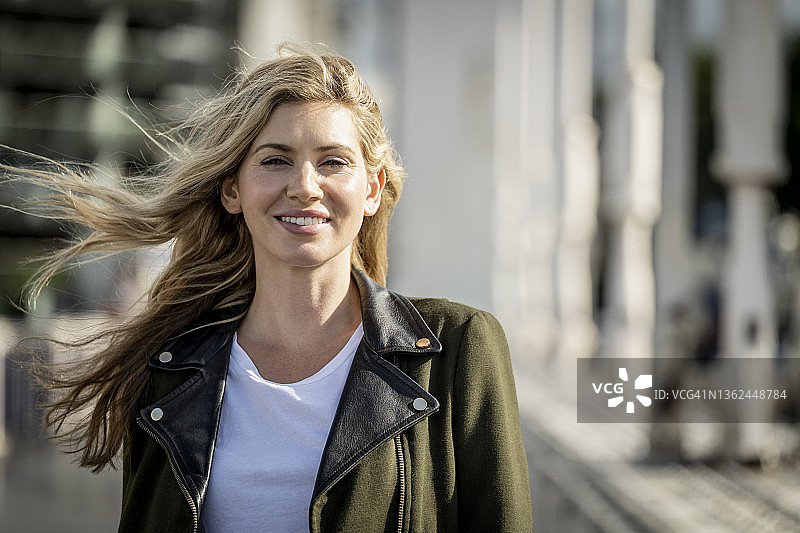 在阳光下行走的快乐30岁左右女子肖像图片素材