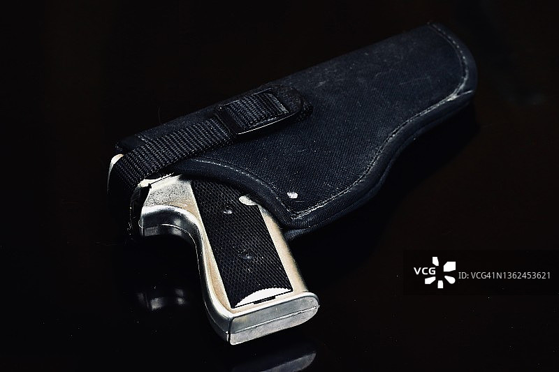 黑色背景上手枪套中的手枪图片素材