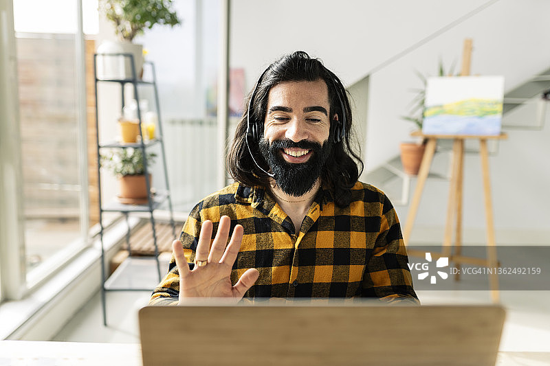 戴着耳机在家进行视频通话的男人图片素材