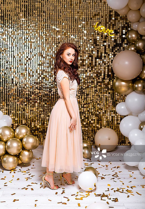 年轻女子庆祝生日，派对装饰和金色气球背景图片素材