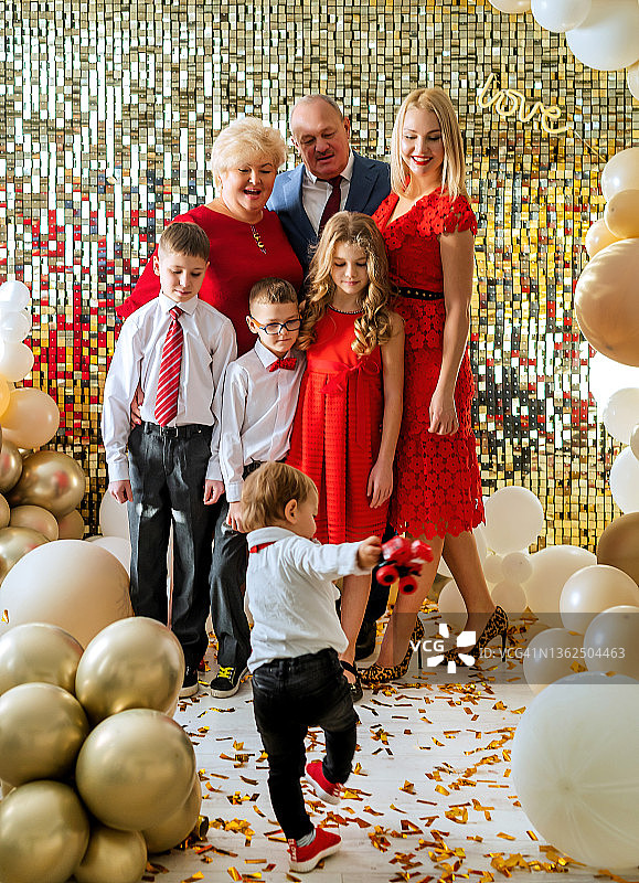 一家六口参加节日派对，气球和亮片营造欢乐气氛图片素材