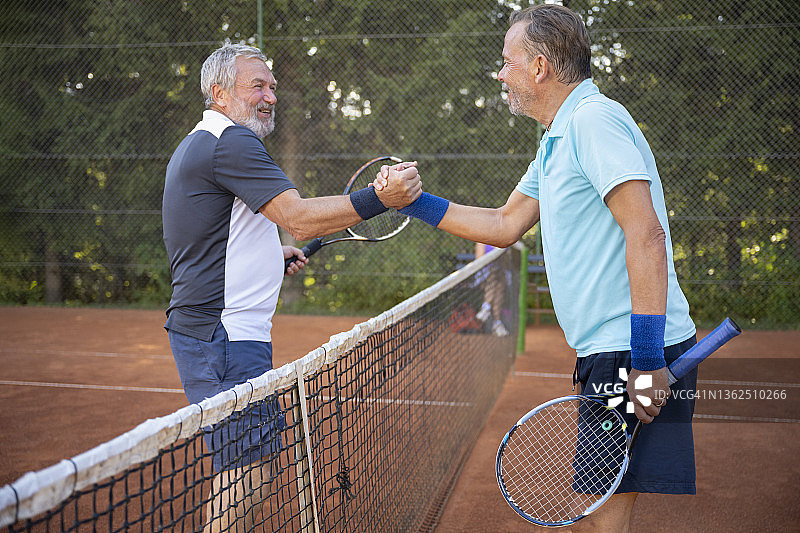 红土球场上握手的网球运动员图片素材