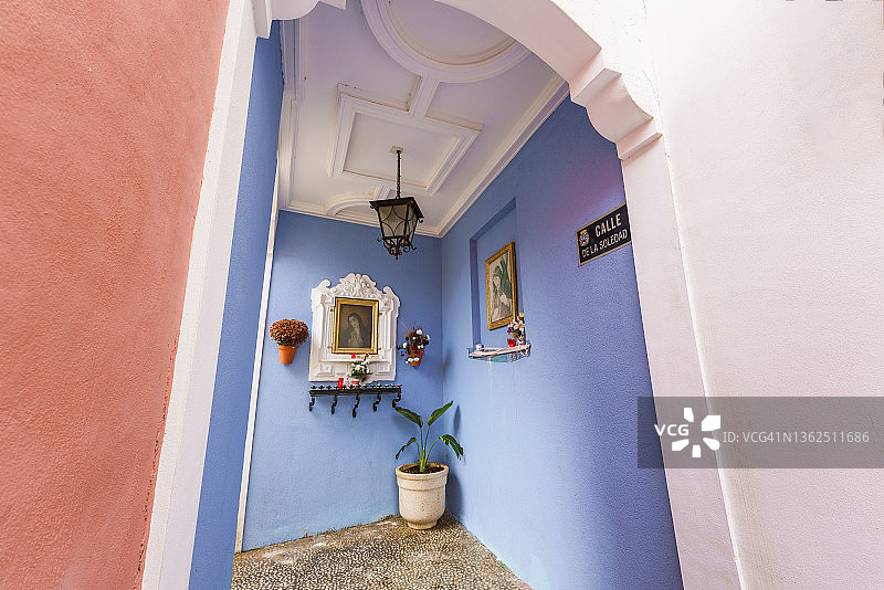 带有宗教标志的狭窄小巷。西班牙卡塔赫纳的Calle de la Soledad图片素材