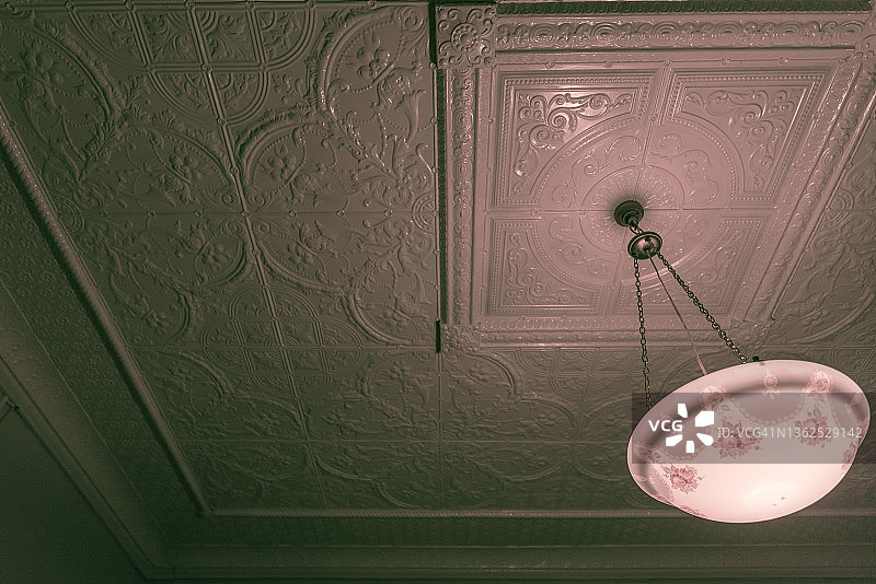 悬挂在压制金属天花板上的老式维多利亚灯罩图片素材