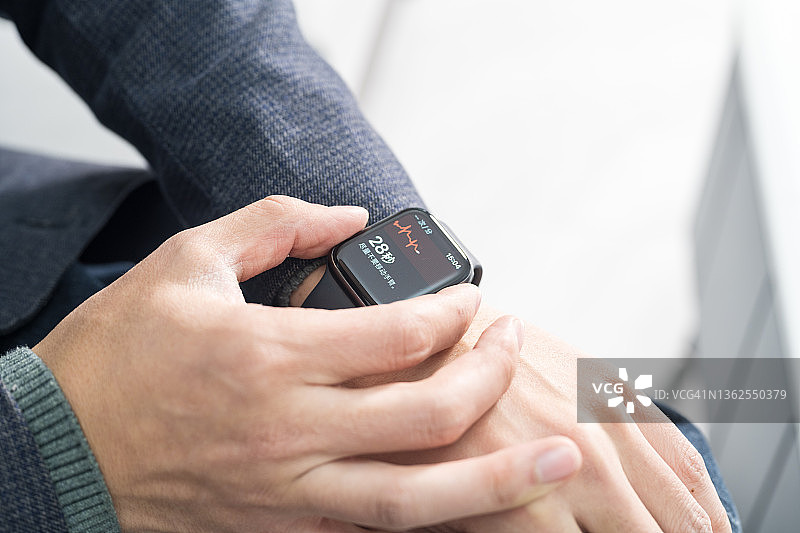 男人用智能手表测量心电图特写图片素材