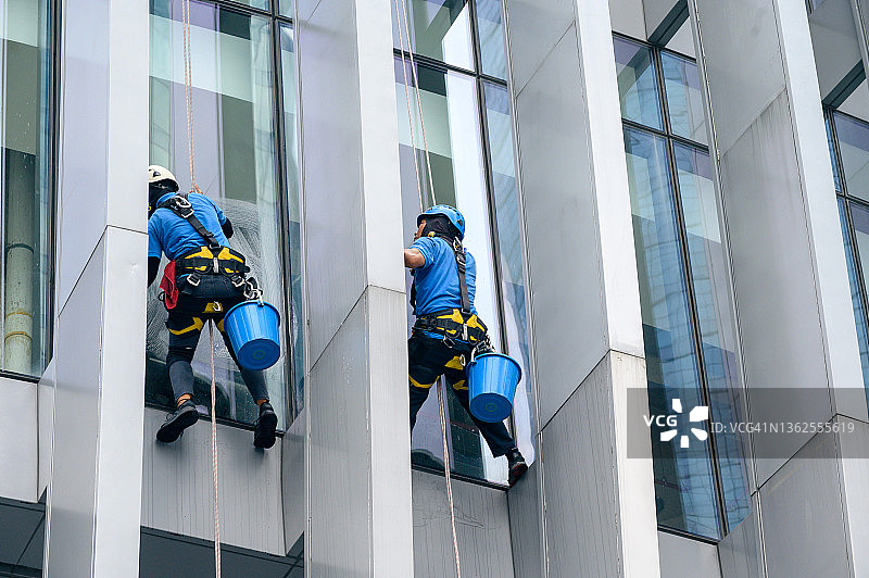清洁工正在高层办公楼的立面上作业图片素材