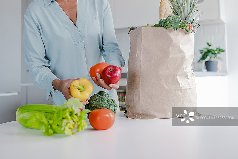 女人打开装满食物的购物袋图片素材