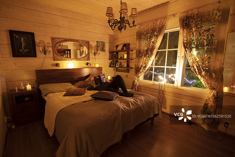 年长的白人妇女在晚上于床上阅读图片素材