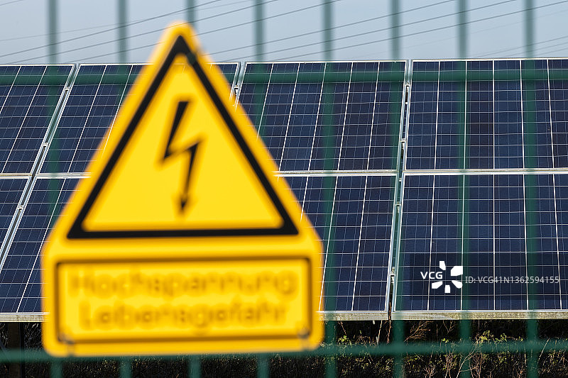 背景为太阳能电池板的高压标志图片素材