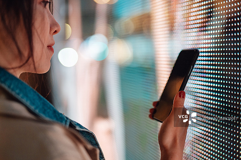 年轻女人在智能手机上使用加密投资App图片素材