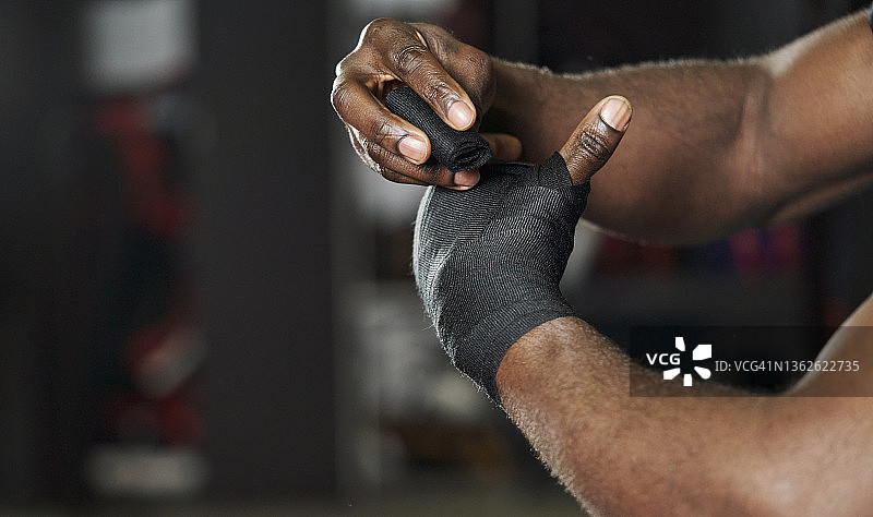 男人在手上缠绕黑色训练胶带特写图片素材