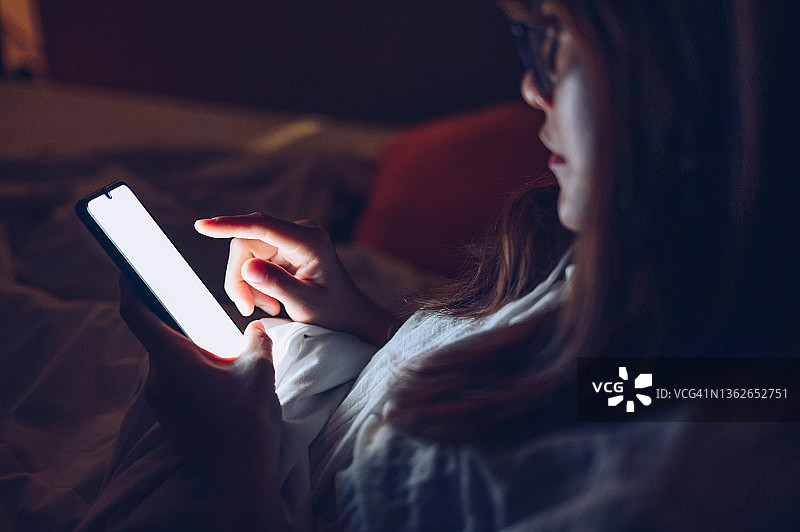 深夜，女子使用智能手机图片素材