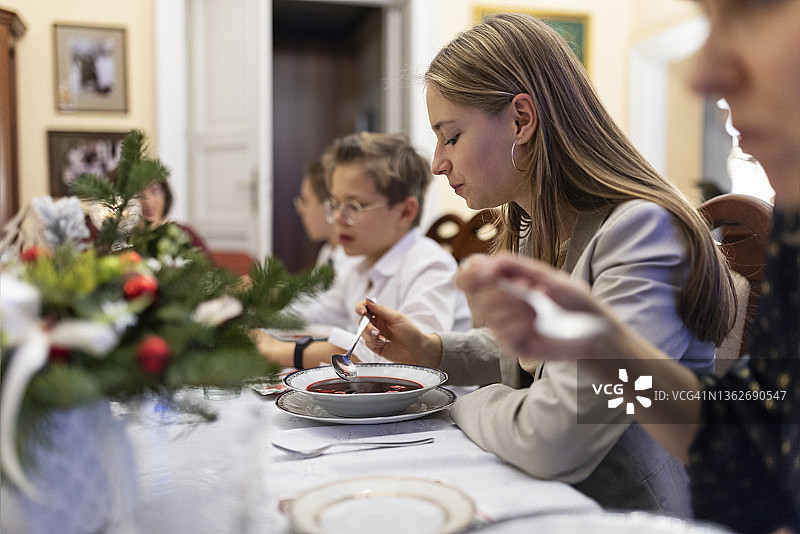 多代同堂家庭在圣诞节前夜晚餐时吃罗宋汤图片素材