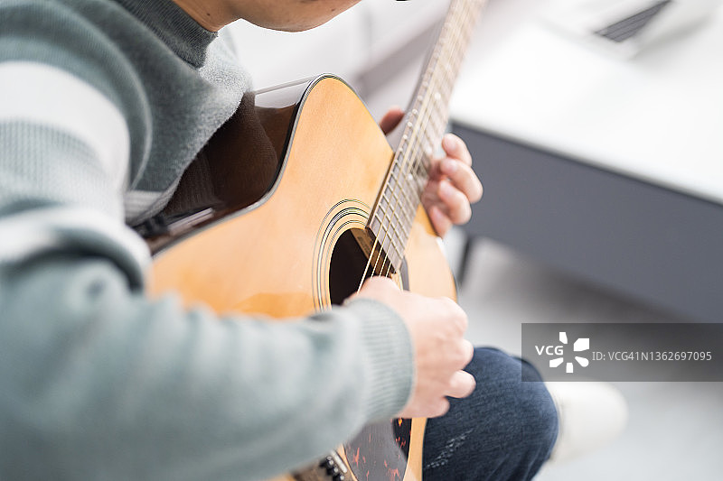 年轻男子弹吉他的特写镜头图片素材