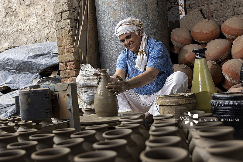 男人在转盘上制作陶罐图片素材
