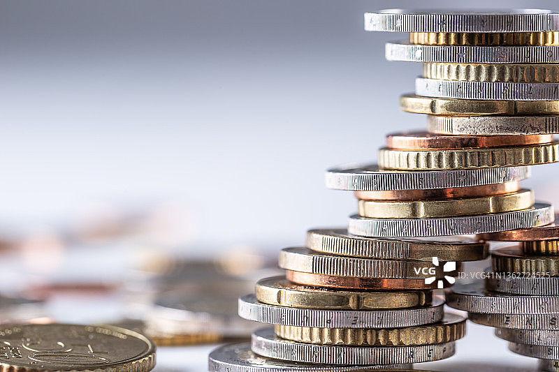 白色桌面上平衡的欧元硬币塔图片素材