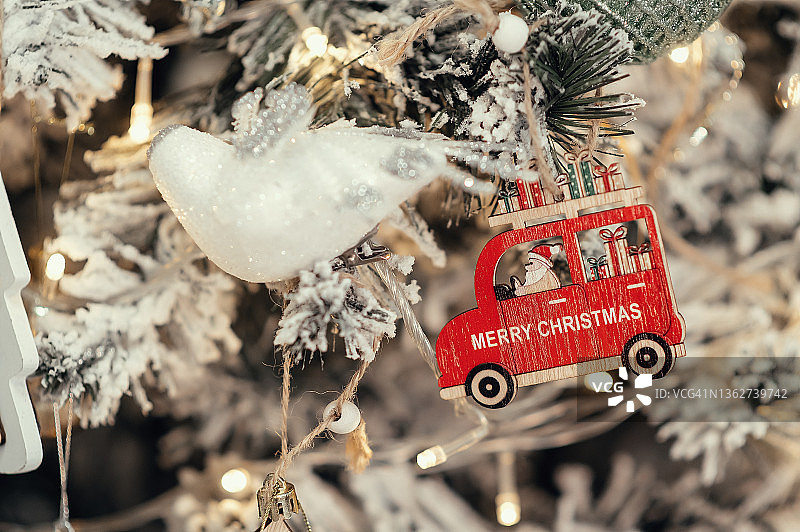 挂在带灯圣诞树上的木制红色圣诞老人汽车，新年2022，2023，圣诞节图片素材